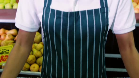 Female staff holding fresh green apples in wicker basket