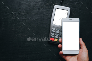 smartphone. Clear white mockup screen template of phone and pos terminal on dark wooden desk with side copy space
