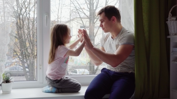Little Girl Playing with Her Father at Okay on Windowsill