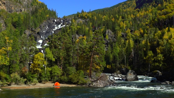 Autumn Forest and Rocky Waterfall. Tent Is on the Shore of the River