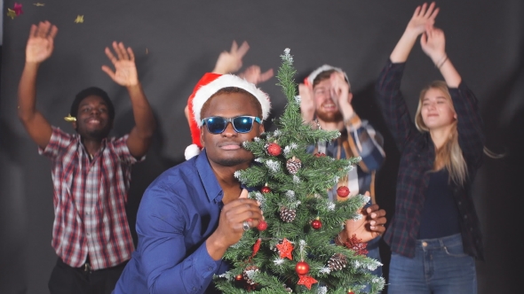 Multi Ethnic Group of Young People at Christmas Party in Studio, Dancing and Smiling Into Camera.