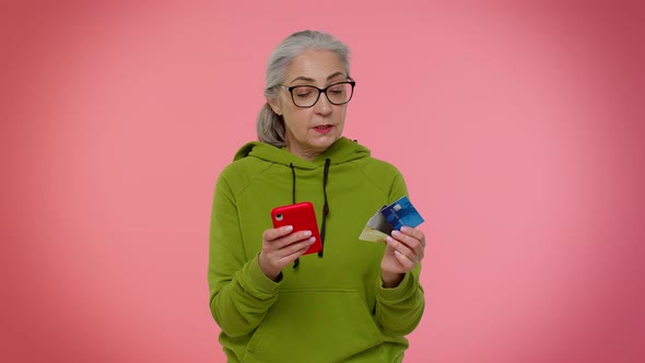 Senior Old Granny Woman Using Credit Plastic Cards and Mobile Phone Purchases Online Shopping