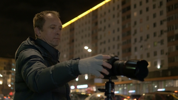 A Professional Photographer, Photographs the Movement of Cars in the Evening