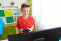 boy with gamepad playing video game on computer - PhotoDune Item for Sale