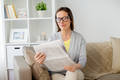 woman in glasses reading newspaper at home - PhotoDune Item for Sale
