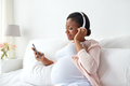 pregnant woman in headphones with smartphone - PhotoDune Item for Sale