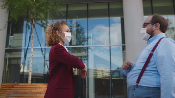 Office Workers in Medical Mask Shake Meeting and Greet Each Other Bumping Elbows Outdoors