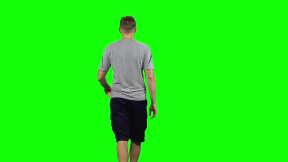 Back View of Guy Is Walking and Drinking Coffee From a Paper Cup. Chroma Key