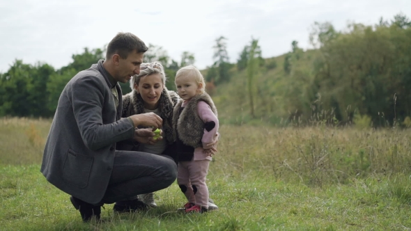 Happy Family Rest on the Nature with Kid, Blowing and Catching Bubbles