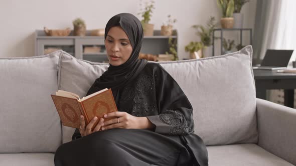 Muslim Woman Reading Koran at Home