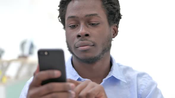 Closeup Shot of African Man Scrolling on Cellphone