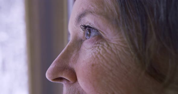 Closeup in Profile Look of an Elderly Woman in a Window with a Multitude of Wrinkles with a Makeup