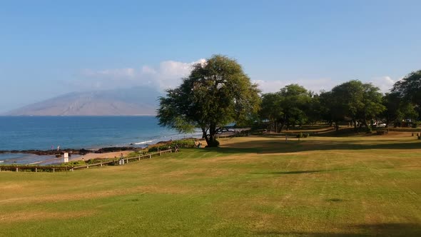 Aerial footage from the lawn of Kamaole III Beach park in the morning.  Maui, Hawaii.