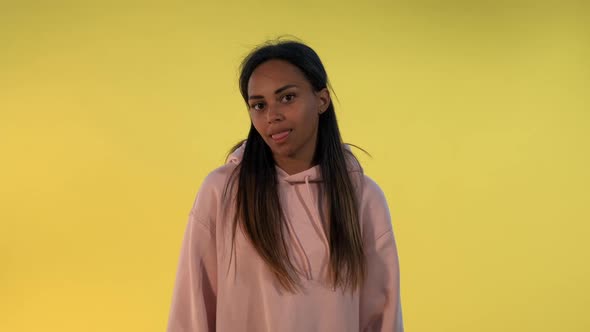 Multiethnic Girl Making Funny Faces on Yellow Background.