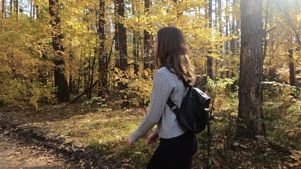 The Girl Walks Through the Autumn Forest