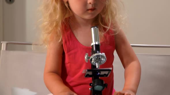Little Girl Looks Fun Through a Microscope