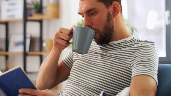 Man Reading Book and Drinking Coffee at Home