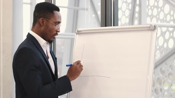African American Architec Engineer Drawing Plan on Flip Chart at Office