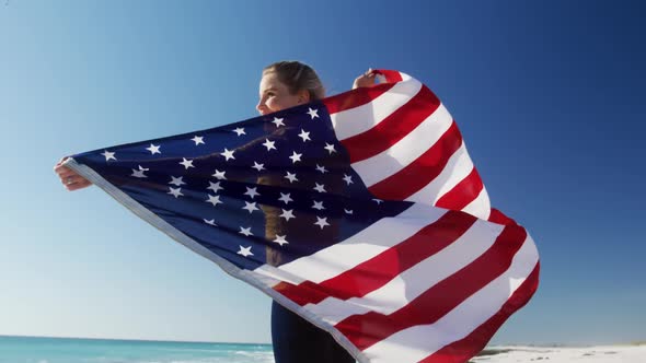 Woman holding American flag on the beach