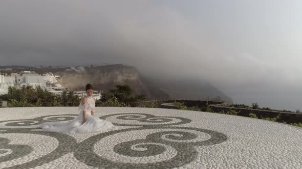 Aerial view of woman with wedding dress, Santorini island, Greece.