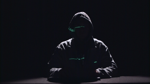 Spy Is Typing Virus Patches on the Keyboard for Hacking. Black Background. Silhouette