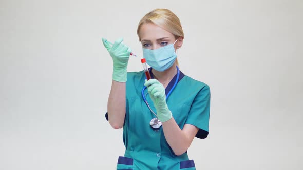 Doctor Nurse Woman Wearing Protective Mask and Latex Gloves - Holding Blood Test Tube and Syringe