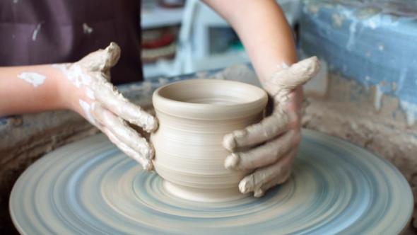 Little Girl Having Fun Playing with Clay on a Pottery Wheel.