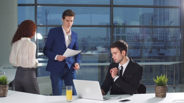 Businessman Under Stress at Work. Colleagues Bring a Lot of Documents for Verification.