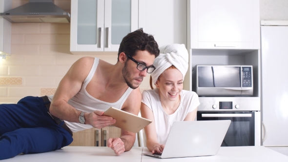 Young Business Couple Working with Laptop at Home in Kitchen.