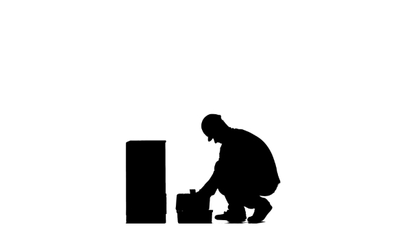 Builder in a Helmet Hammers a Nail with a Hammer. Silhouette. White Background