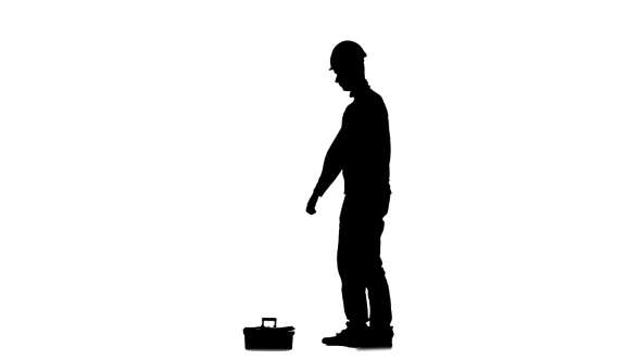 Builder in a Helmet Hammers a Nail with a Hammer. Silhouette. White Background