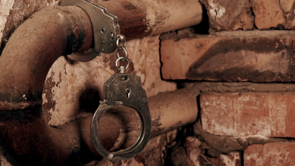 the Handcuffs Chained To a Pipe in an Old Building