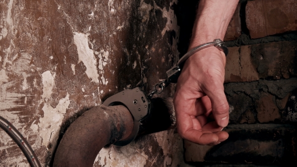 Man Handcuffed To a Pipe in an Old Building
