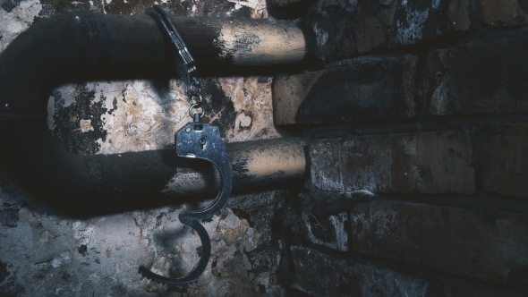 the Handcuffs Chained To a Pipe in an Old Building