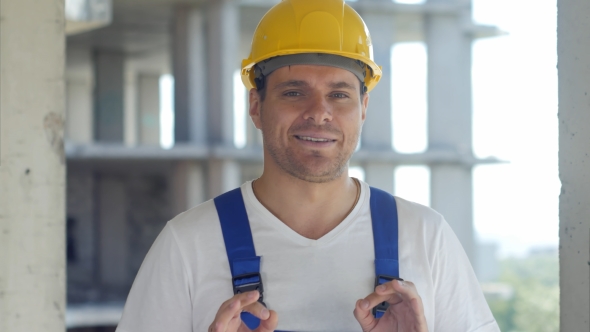 Construction Worker Talks To Camera in Front of Building Site