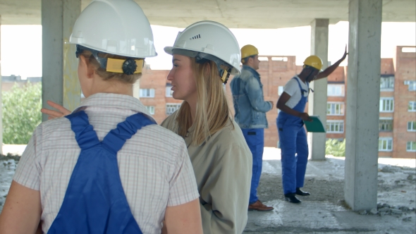 Young Architecture and Female Worker Talking at Open Air Construction Site
