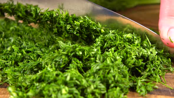 The cook cuts fennel on a wooden cutting board.