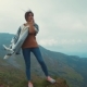 Attractive, Young, Fit Woman in a Sport Outfit and Stylish Poncho Standing on the Rocky Mountain Top - VideoHive Item for Sale