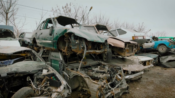 Stacked Wrecked Cars on Grungy Junkyard alt
