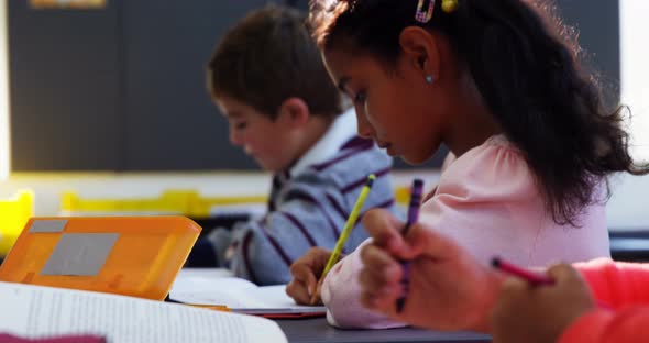 Attentive schoolkids doing their homework in classroom