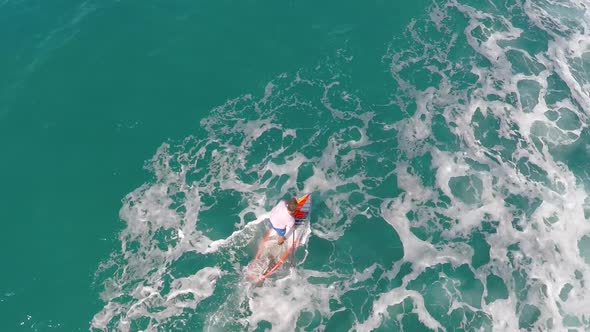 Aerial view of a man sup stand-up paddleboard surfing in Hawaii