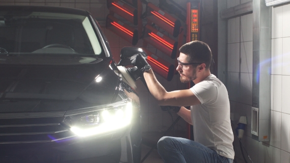 Master Polishes the Car in a Car Workshop.