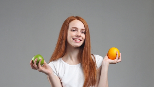 Beautiful Girl Chooses Between Orange or Apple