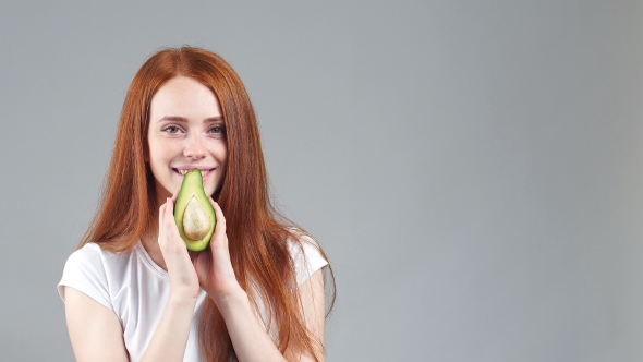 Smiling Girl Showing a Little Avocado Healthy Fruit.