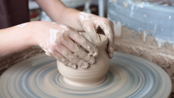 Little Girl Is Molding at Pottery Wheel Creating a Clay Bowl, Dirty Kid's Hands.