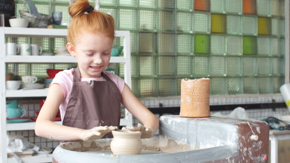 Happy Kid Is Pressing a Clay Vase on Wheel, Kid Is Working at Pottery Wheel Slowly