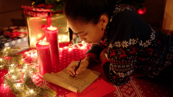 A Little Girl Is Lying and Writing a Letter To Santa Claus