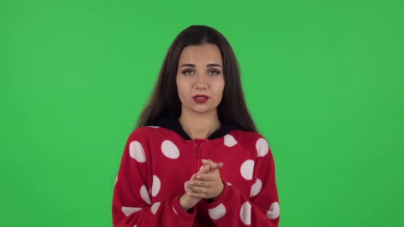 Portrait of Beautiful Girl in Red Fleece Pajamas Is Clapping Her Hands Indifferent. Green Screen