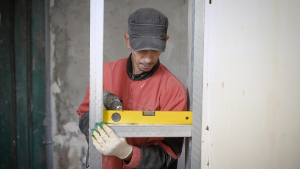 Professional Constructor Using Leveling Gauge for Measuring on Building Site alt