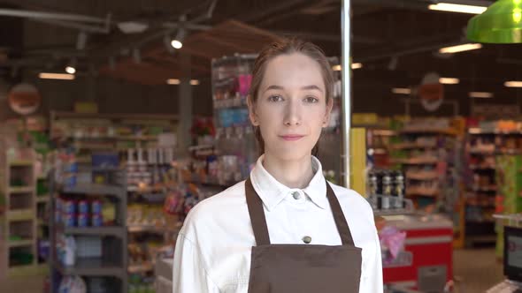 The Girl Supermarket Cashier Smiles for the Camera